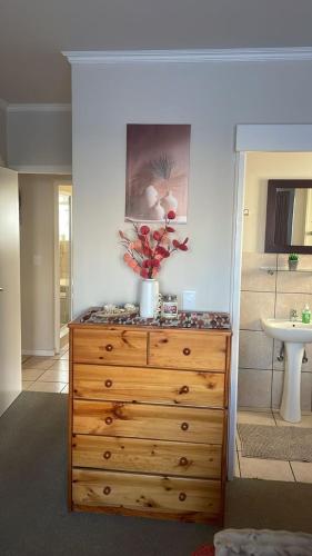 a wooden dresser with a plant on top of it at Heaven at Sea in Mossel Bay