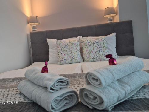 a bed with towels and pillows on it at Park Apartman in Kaposvár