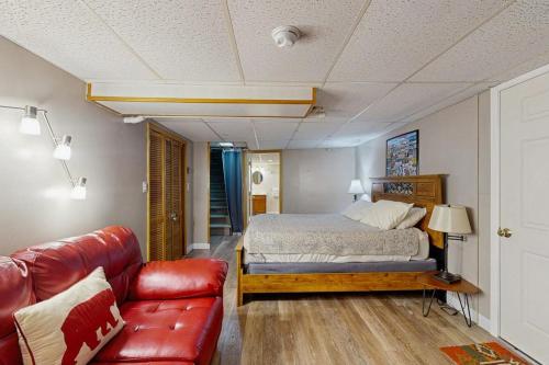 a bedroom with a bed and a leather couch at Perfect Mountain Location in North Conway