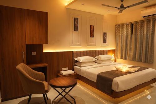 a bedroom with a bed and a table and a chair at Hotel Madhuram Shivpuri MP in Shivpurī
