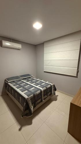 a bedroom with a bed in the corner of a room at Apartamento 2 quartos com ar-condicionado, Wi-Fi e Netflix in Americana