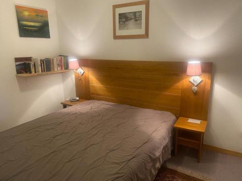 a bedroom with a bed and two tables with lamps at Appartement avec balcon 6 personnes Superdévoluy in Le Dévoluy