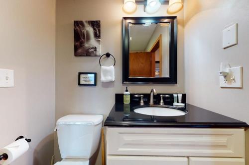 a bathroom with a sink and a toilet and a mirror at New England Treasure in North Conway