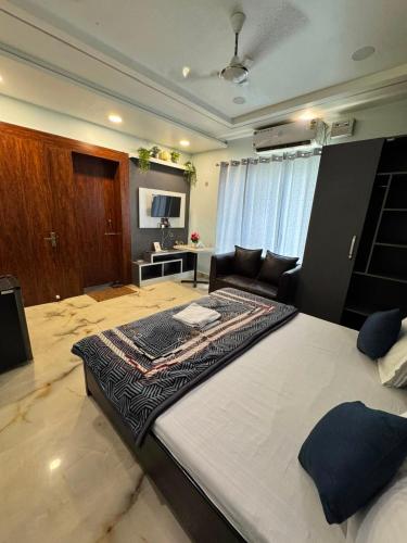 a large bedroom with a large bed and a couch at Atmosphere Hotel & Restaurant in Alīgarh