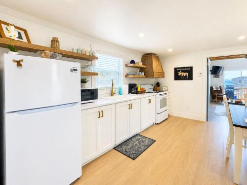 a kitchen with white cabinets and a white refrigerator at Wild Cove Nook in Twillingate