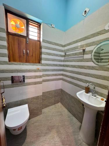 a bathroom with a toilet and a sink at Atmosphere Hotel & Restaurant in Alīgarh