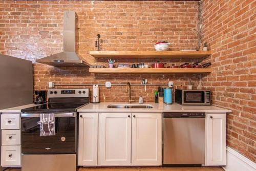 a kitchen with white cabinets and a brick wall at 406 Canyon Rd #1 in Ogden