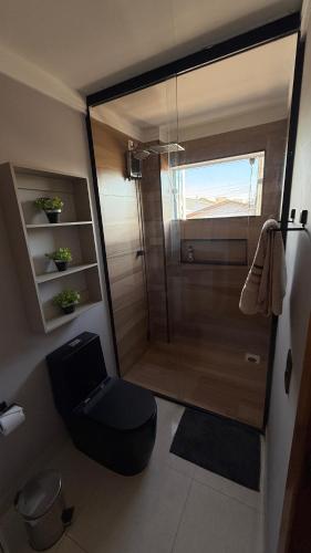 a small bathroom with a toilet and a shower at Apartamento 2 quartos com ar-condicionado, Wi-Fi e Netflix in Americana