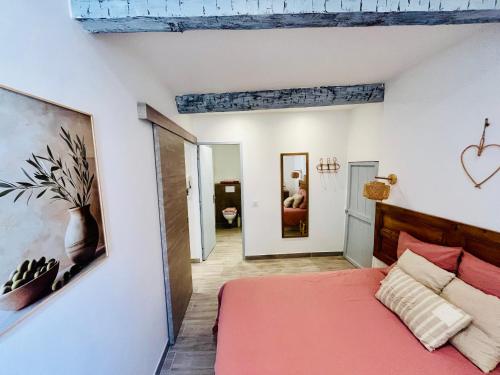 a bedroom with a red bed and a painting on the wall at Appartement T2 centre village in Cucuron