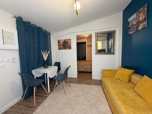 a living room with a couch and a table at Studio moderne climatisé - Parking gratuit - Paris & Disney in Ormesson-sur-Marne
