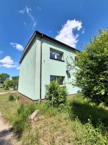 a green building on the side of a field at Mazurska przystań 2 in Gąsiorowo Olsztyneckie
