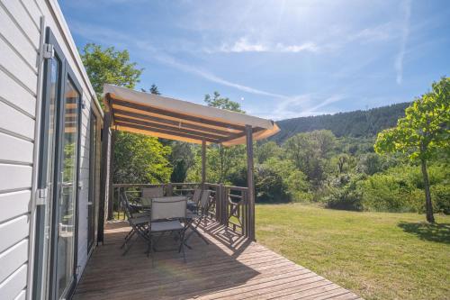 a deck with a canopy and a table and chairs at Ludocamping in Lussas
