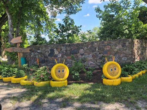 a group of yellow containers with faces painted on them at Mazurska przystań 2 in Gąsiorowo Olsztyneckie