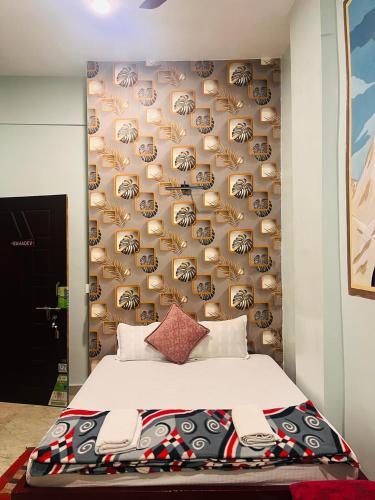 a bedroom with a large bed and a wall with aiger at Kashi Vibes Hostel in Varanasi