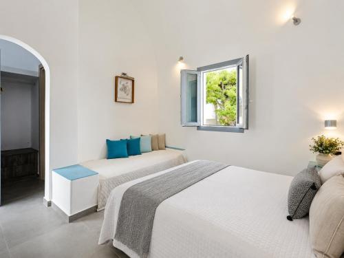 two beds in a white room with a window at Nest & Rest Perissa in Perissa