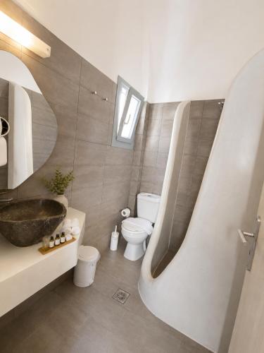 a bathroom with a tub and a toilet and a sink at Nest & Rest Perissa in Perissa