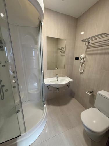 a bathroom with a shower and a toilet and a sink at Hotel CHG LEYTON in Foz