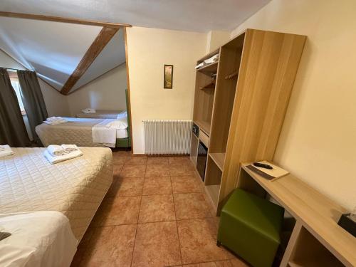 ein Hotelzimmer mit zwei Betten und ein Zimmer mit in der Unterkunft Hotel Trieste in Tarvis
