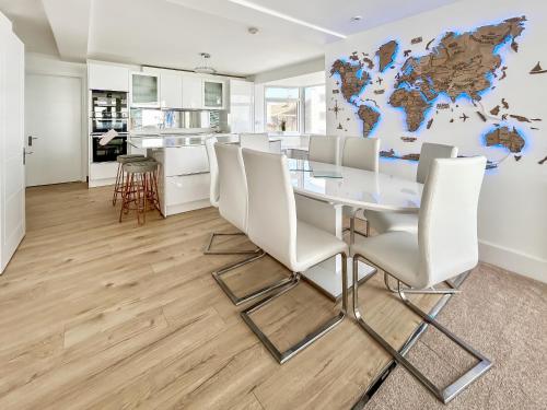 a dining room with a glass table and white chairs at The Beach House in Worthing