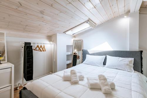a bedroom with a large white bed with white pillows at Alkyoni Samos Maisonette in Mytilinioí