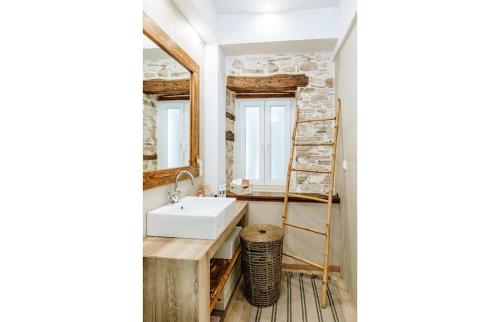 a bathroom with a sink and a mirror at Alkyoni Samos Maisonette in Mytilinioí