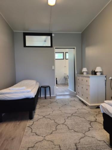 a bedroom with two beds and a dresser and a mirror at Your loft in Seinäjoki