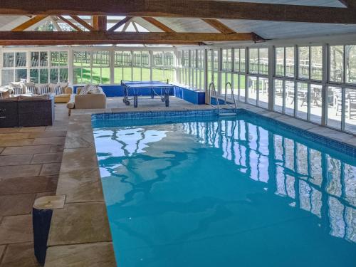 a large swimming pool with a table in a building at Lily Pad 9 - Uk43919 in Nassington