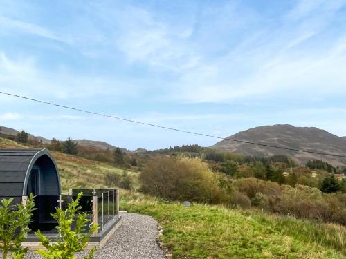 a small building on a gravel road with mountains in the background at Totaig - Uk50717 in Kirkton
