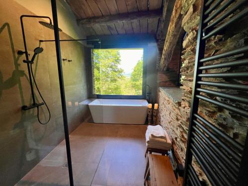 a bathroom with a bath tub and a window at CABAÑA SUITE Deluxe in A Pontenova