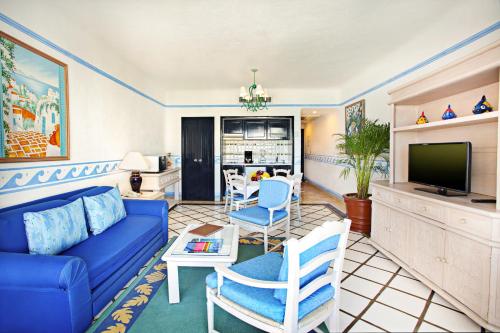 a living room with a blue couch and a tv at Pueblo Bonito Los Cabos Blanco Beach Resort - All Inclusive in Cabo San Lucas