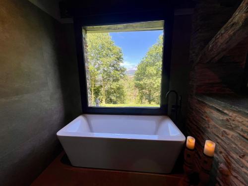 a bath tub in a bathroom with a window at CABAÑA SUITE Deluxe in A Pontenova