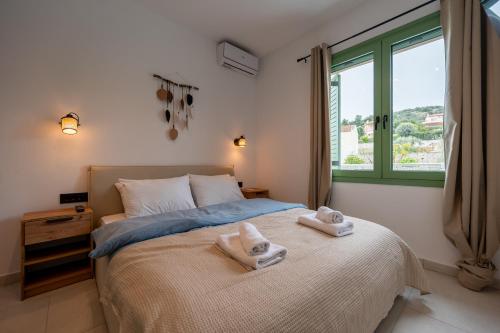 a bedroom with a bed with towels on it at Asini deluxe suite 6, with rooftop terrace and breathtaking views in Asíni