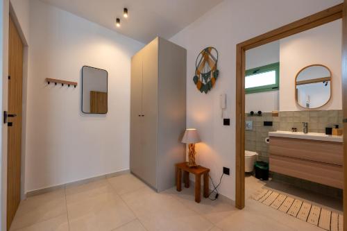 a bathroom with a sink and a mirror at Asini deluxe suite 6, with rooftop terrace and breathtaking views in Asíni