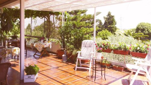 a patio with a chair and a lot of plants at Giogaia in Modica