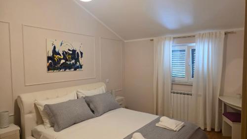 a bedroom with a white bed and a window at Apartment Luce in Pićan