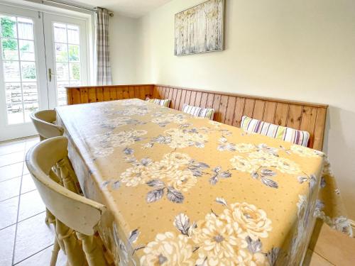 a dining room table with a floral table cloth on it at Lily Pad 2 - Uk43901 in Nassington