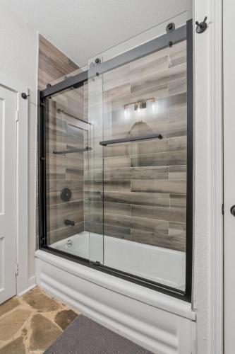 a shower with a glass door in a bathroom at 3BR Cabin Sleeps 10 Fenced Yard in Oklahoma City