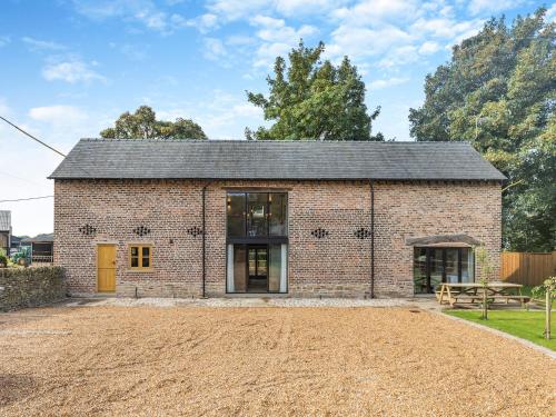 a brick building with a yellow door and a yard at Shepherds Barn in Bollington