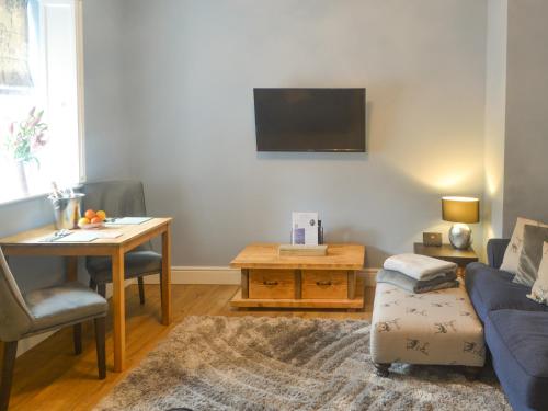 a living room with a couch and a table at Bluebell Cottage in Alnwick