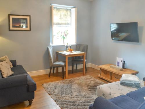 a living room with a table and a couch at Bluebell Cottage in Alnwick