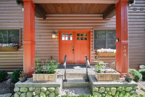 an orange front door of a house with flowers at Cranberry View Lodge in Newland
