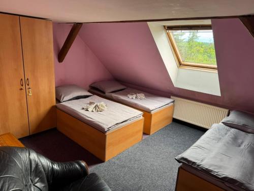 a small room with two beds and a window at Penzion Nord in Hora Svatého Šebestiána