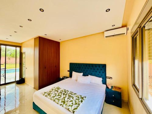 a bedroom with a large bed and a large window at Villa Marrakech Rouge in Aït Zat