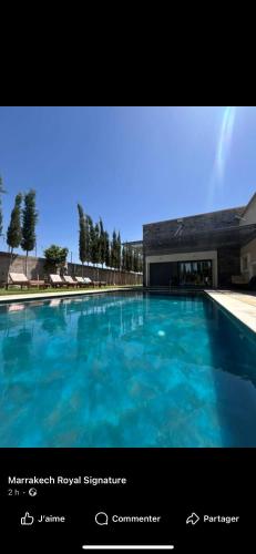 a large blue swimming pool in front of a building at Mandarine de medeline in Ouled el guerne