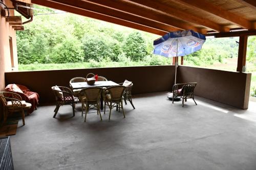 a patio with a table and chairs and an umbrella at Počitniška hiša REMA in Lendava