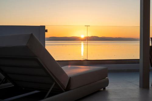 a room with a couch and a view of the ocean at Elysian Beachfront Luxury Suite with Jacuzzi - Sea & City View - ADULTS ONLY in Kos