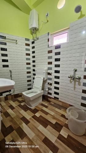 a bathroom with a toilet and a sink at Akshay Guest House in Krishnanagar