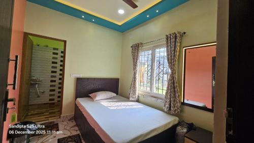 a small bedroom with a bed and a window at Akshay Guest House in Krishnanagar
