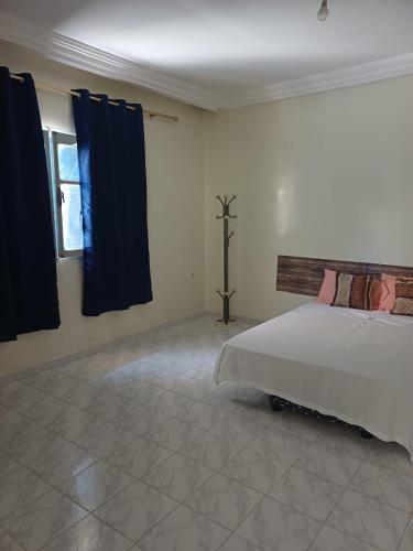 a bedroom with a bed and a window with curtains at Dar Al Yasmine in Tabarka
