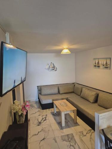 a living room with a couch and a flat screen tv at Ionian Balcony II in Athani